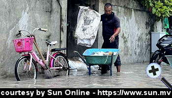 courtesy Sun Online - A person places sandbags in front of a house in Sh. Feevah amid heavy flooding